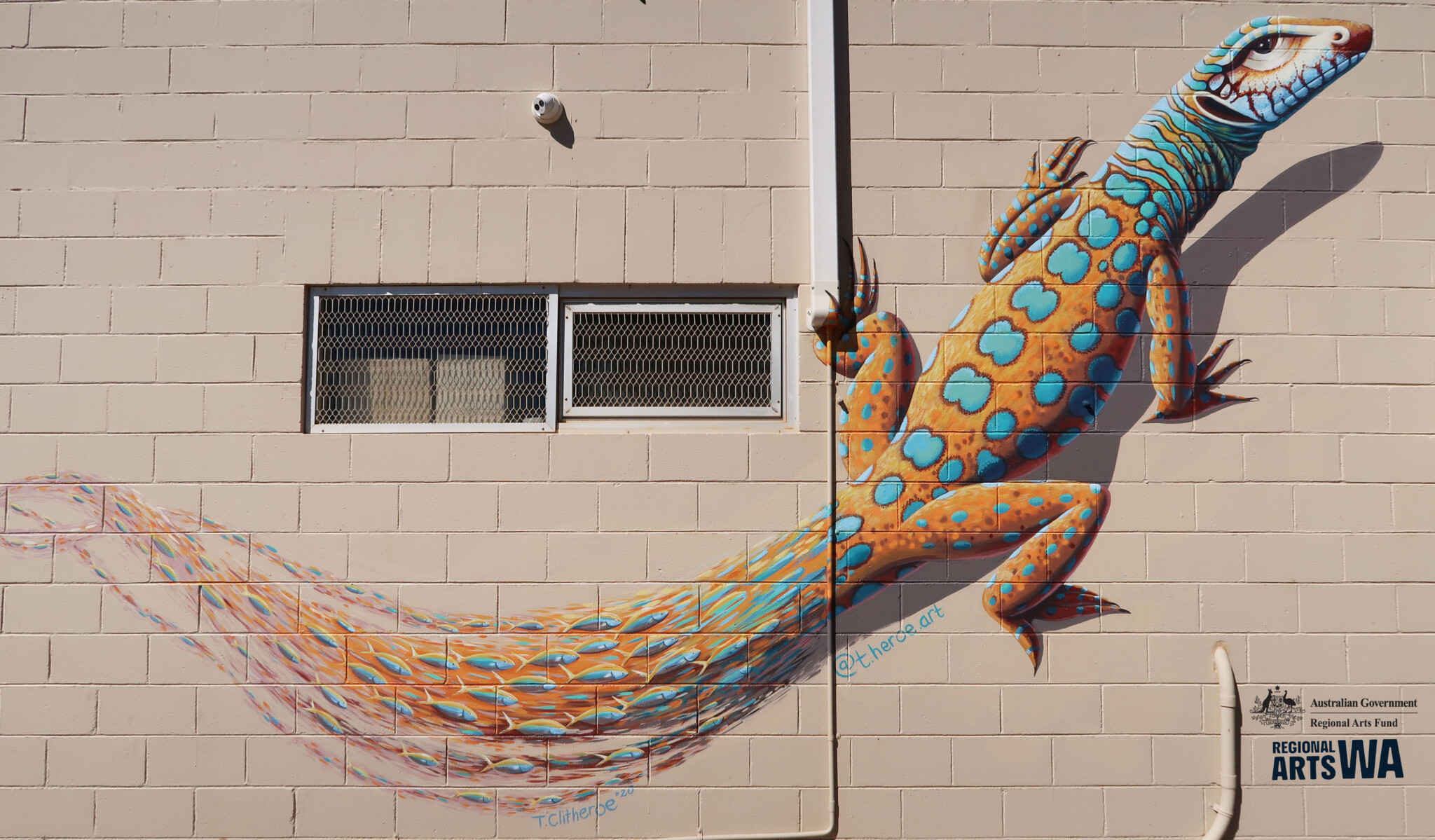 Mural of a lizard, with a 3D effect on the wall.