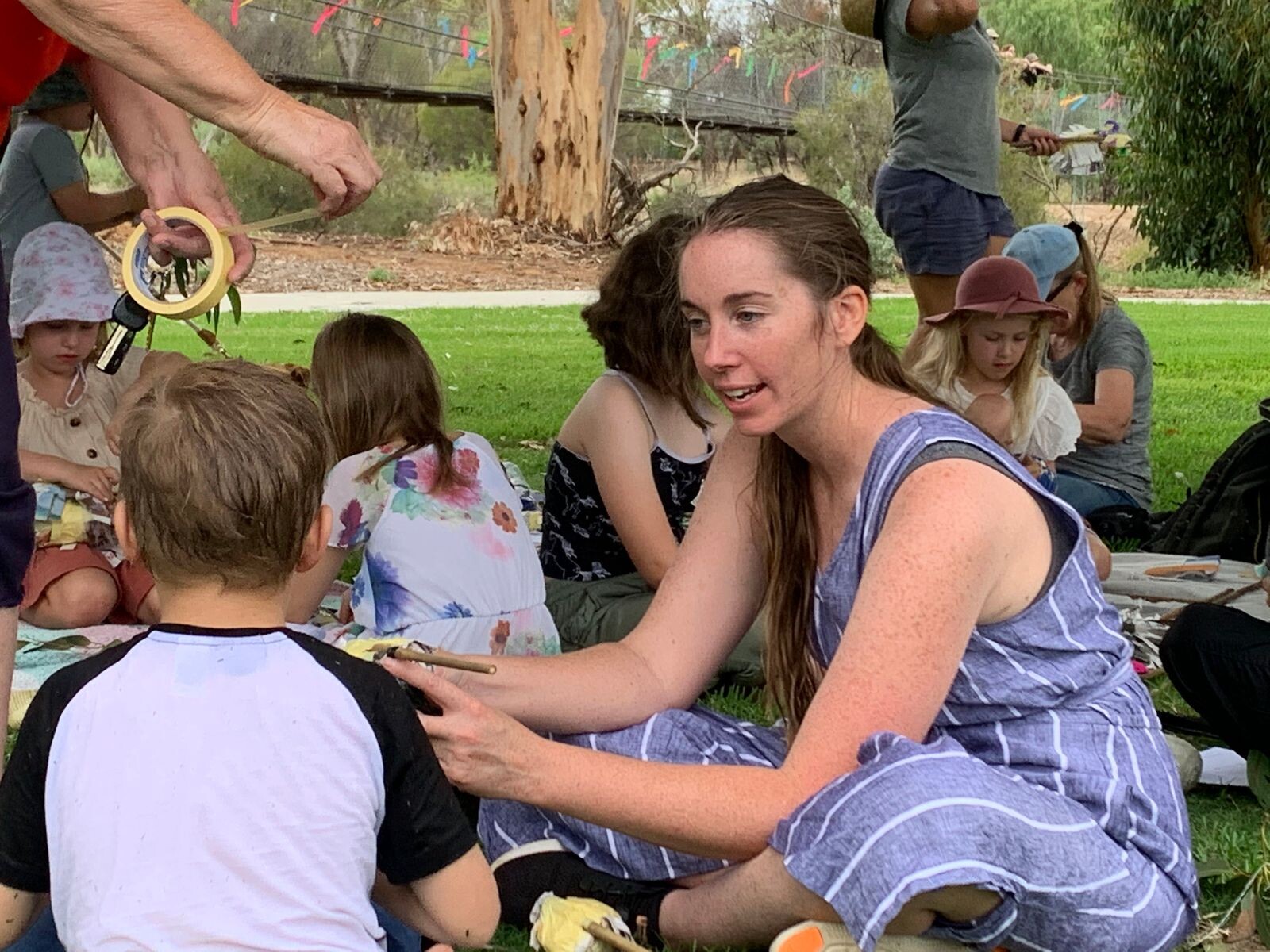 Chloe Flockart explains something to a child for a demonstration. Children in the background with other adults.