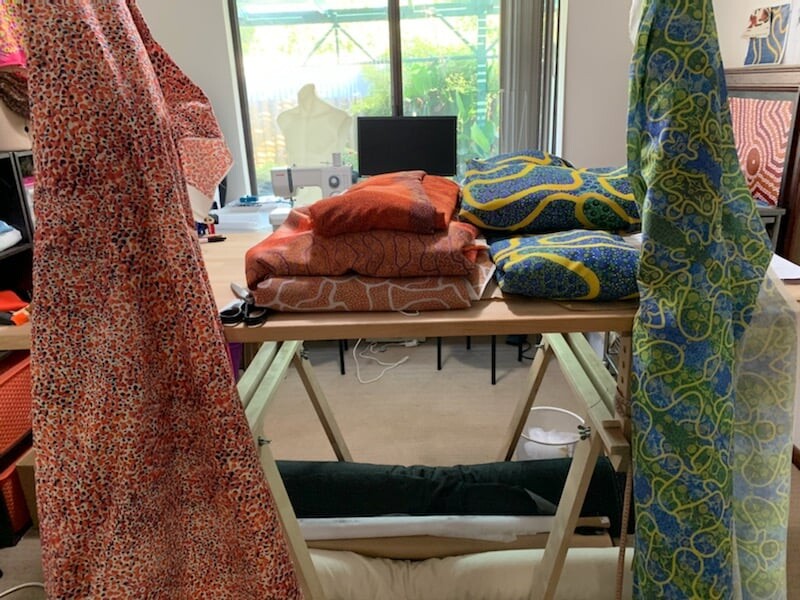 Stacks of fabric with patterns from Bianca's paintings inside a store