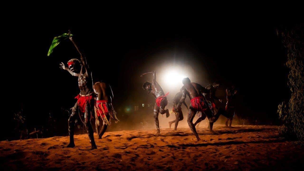 Indigenous men performing a dance at night