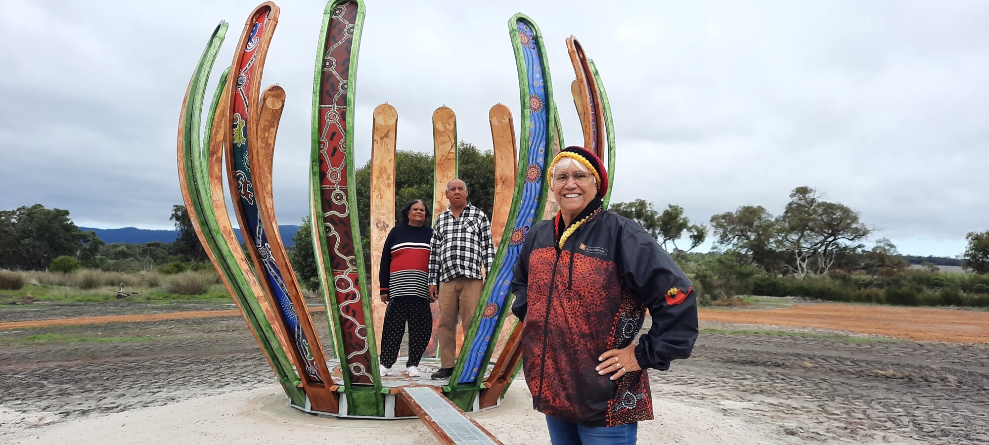 Three people standing next to the Porongurup gene streams sculpture.