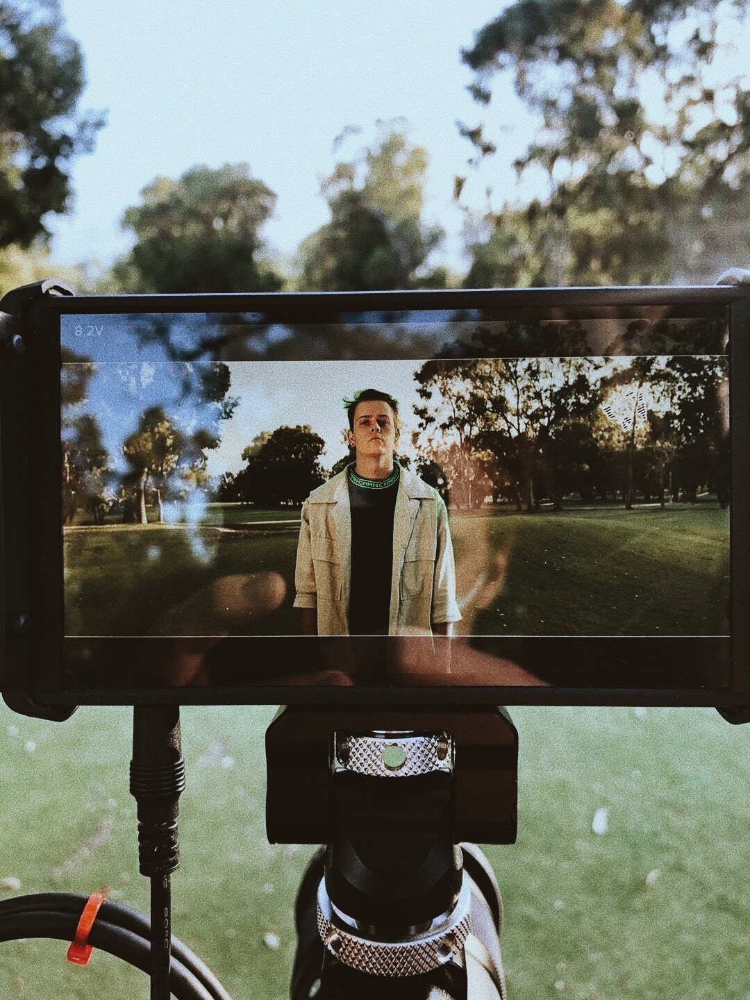 Photo of camera LCD screen showing a still of JOSHUA in a green field.