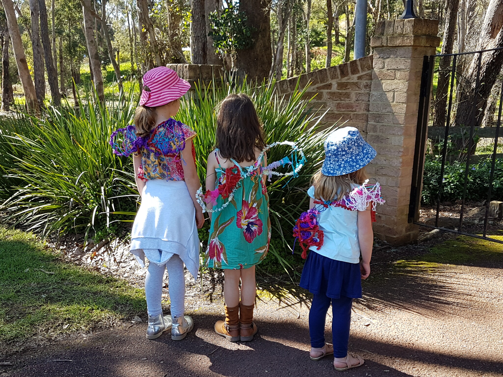 Kids turn with their backs to the camera, showing off their yarn fairy wings.
