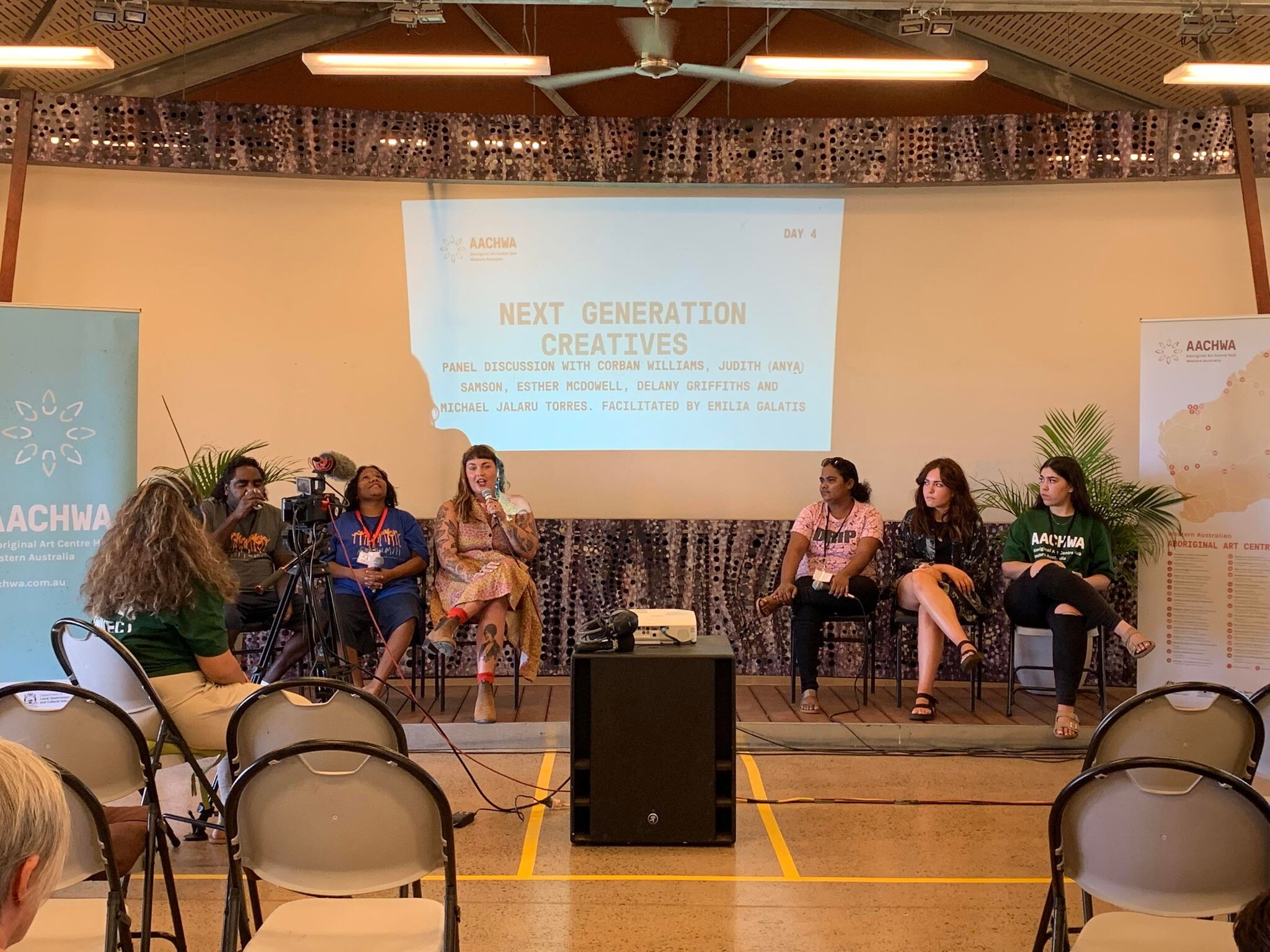 Six people on stage in front of a projection that reads "NEXT GENERATION CREATIVES"