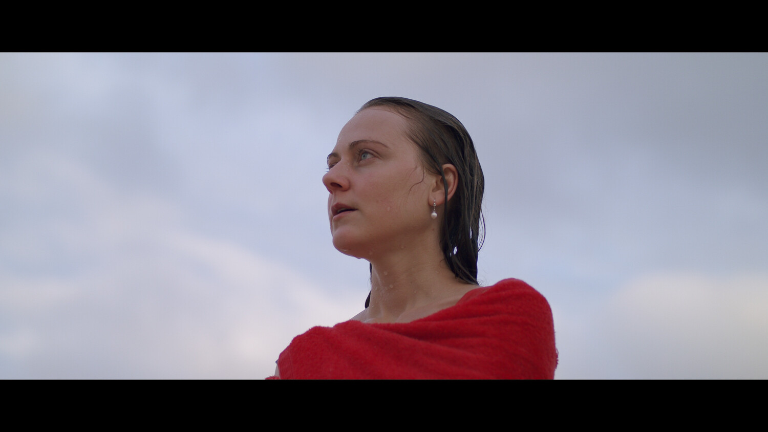 A young woman wrapped in a red towel.