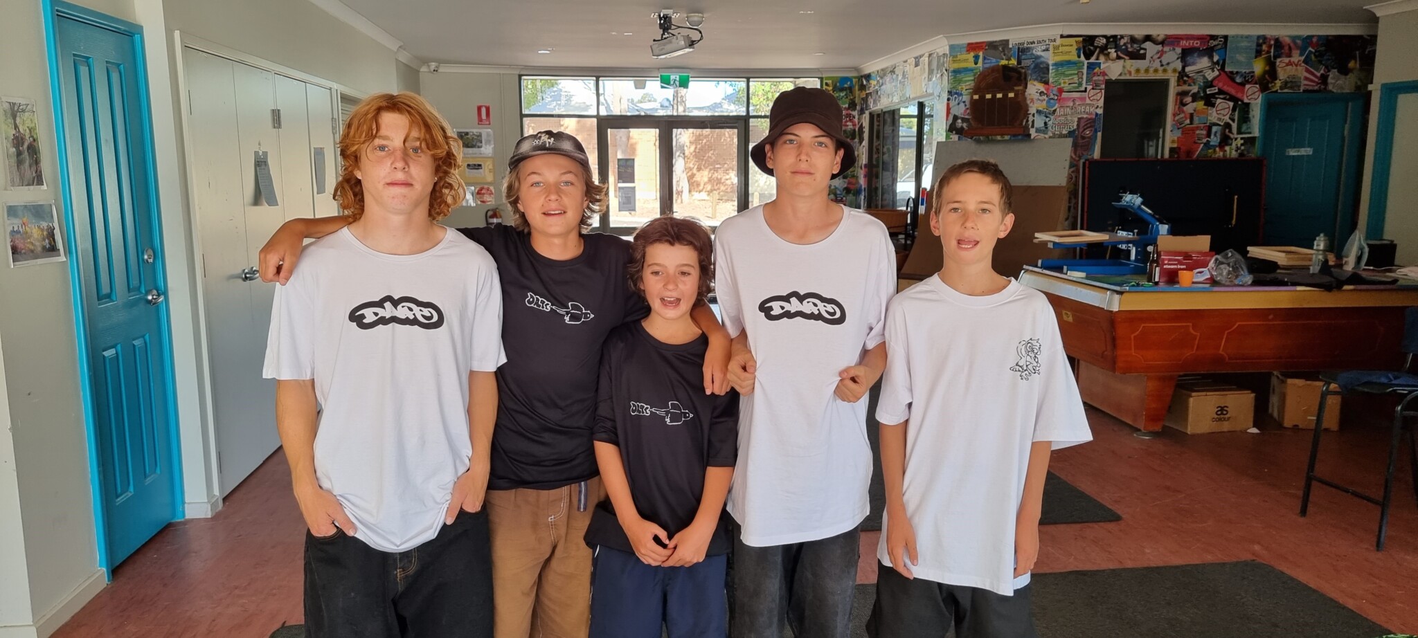 Five young boys wearing T-Shirts screenprinted with a logo reading DAPE.