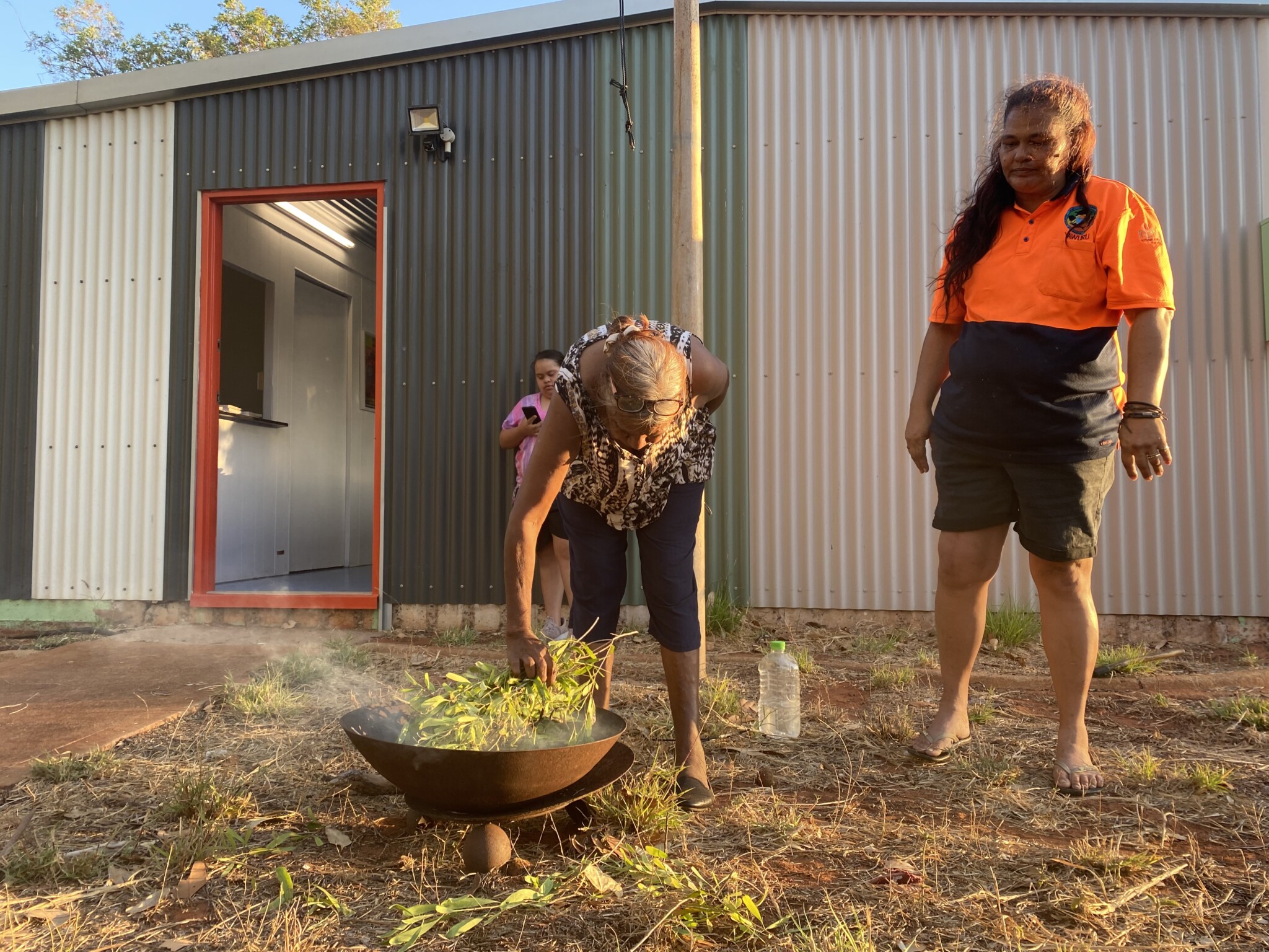 Smoking ceremony outside of a shed.