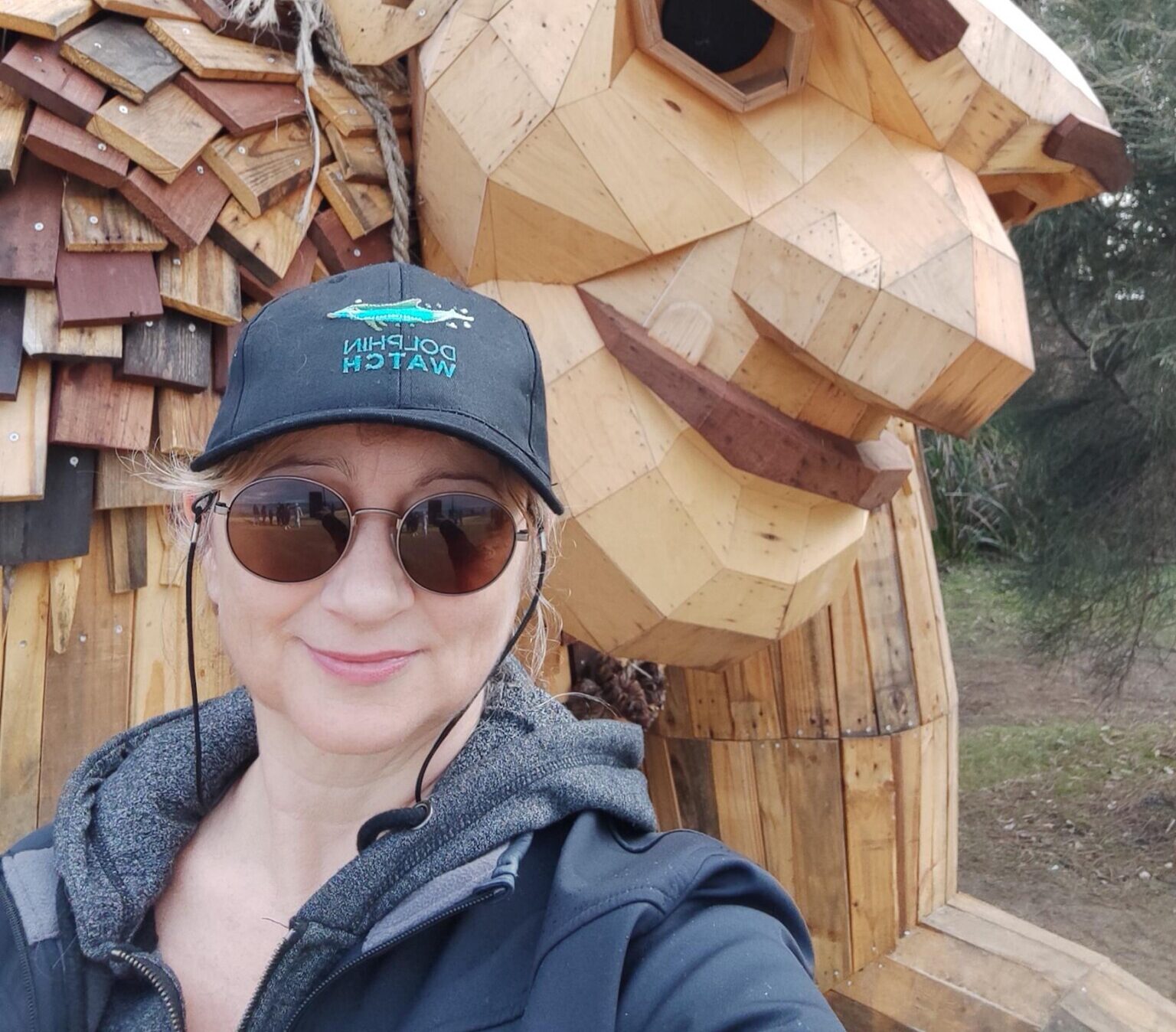 Woman taking a selfie style photo with the Mandurah Giants statue.