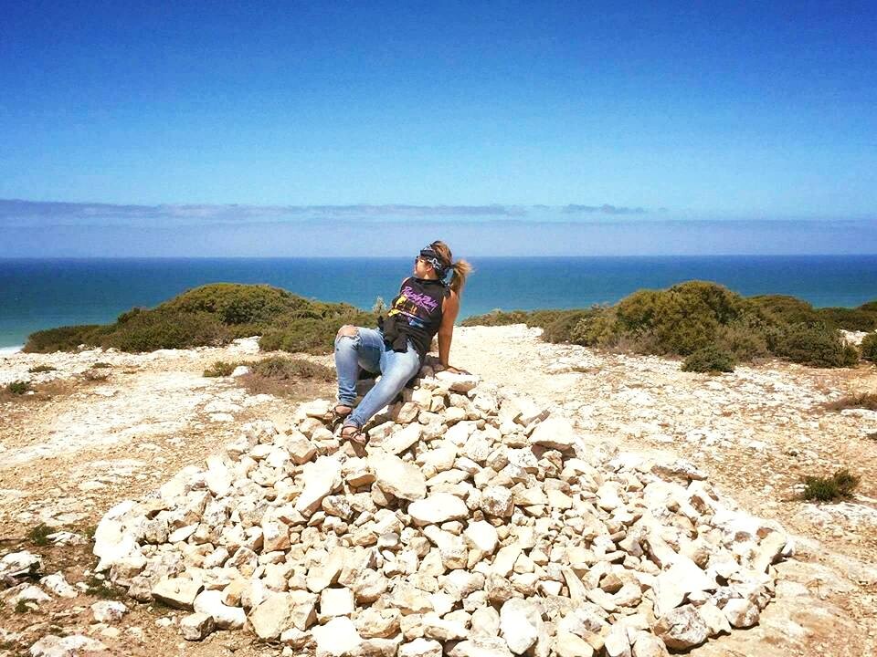 Person sitting on top of rock pile.