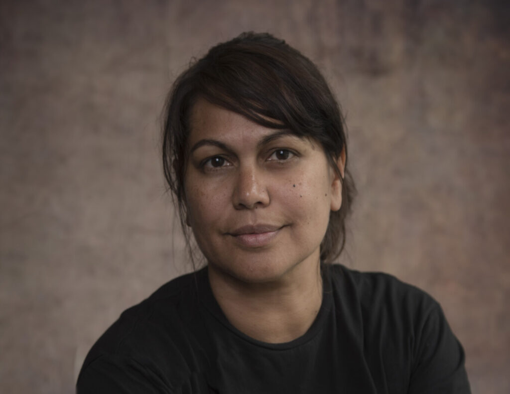 Woman with short brown hair smiles at camera.