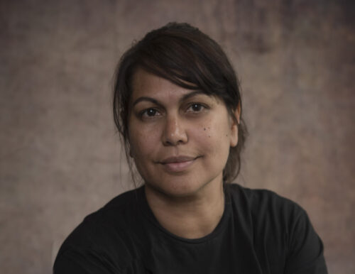 Woman with short brown hair smiles at camera.