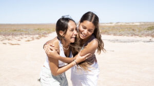 Two Seaside Dancers smiling hugging during Seaside Dancers rehearsal 