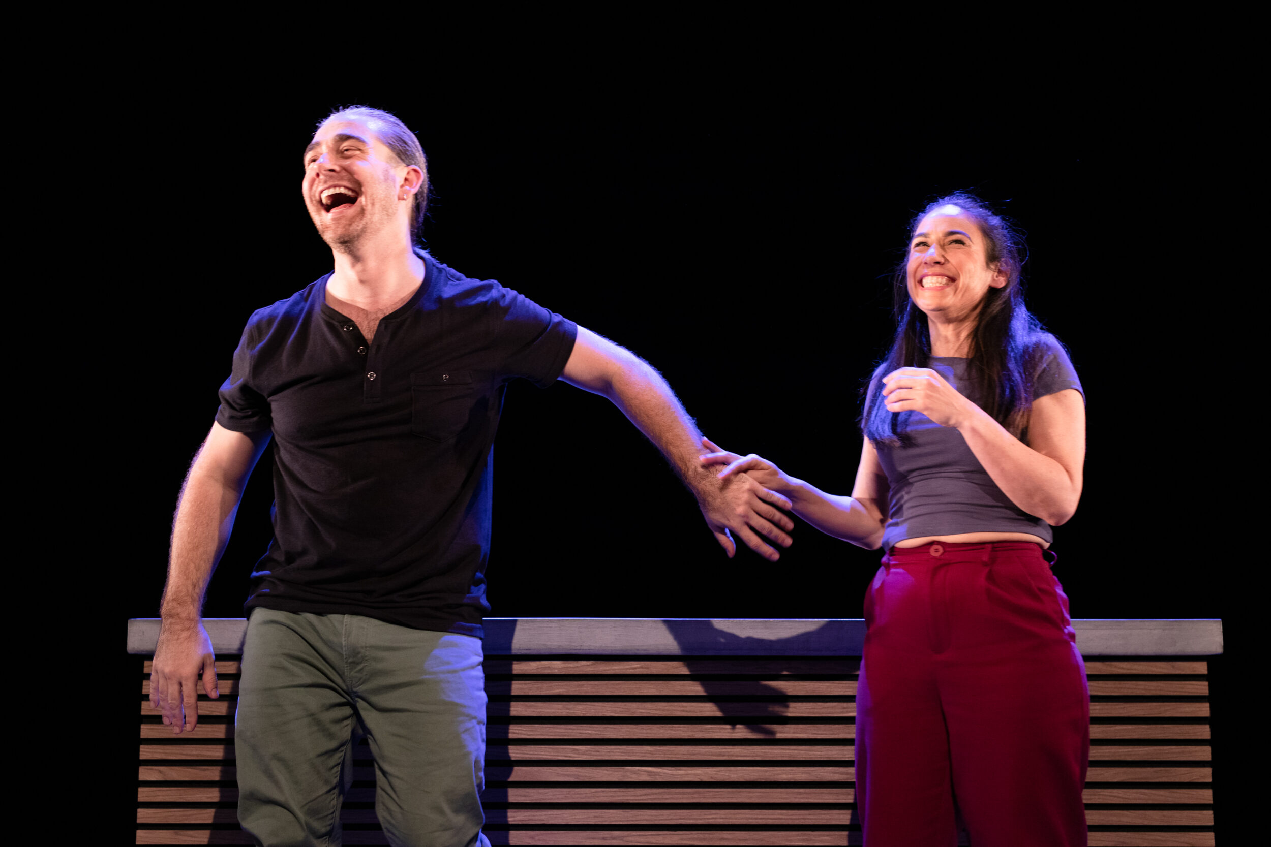 A man and a woman smiling and holding hands