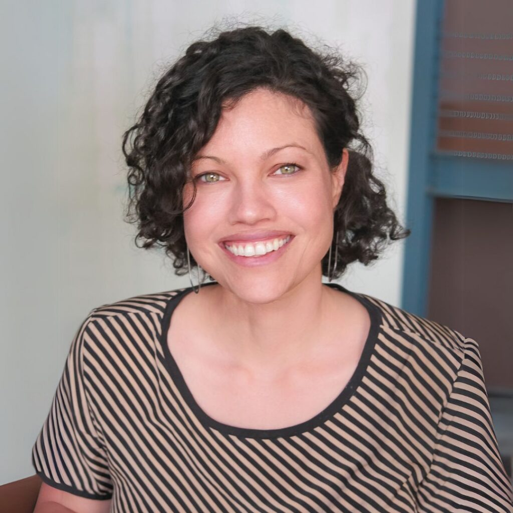 Person with short curly dark hair, wearing a striped top