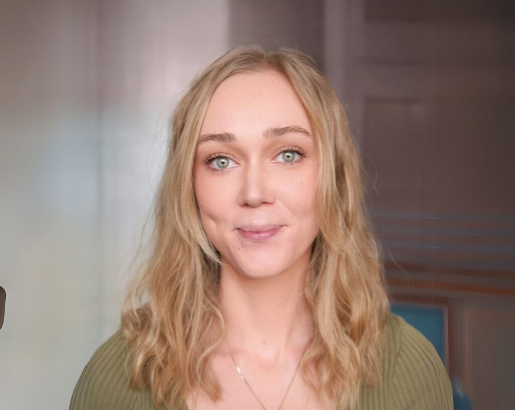 Person with long blonde hair wearing a green top