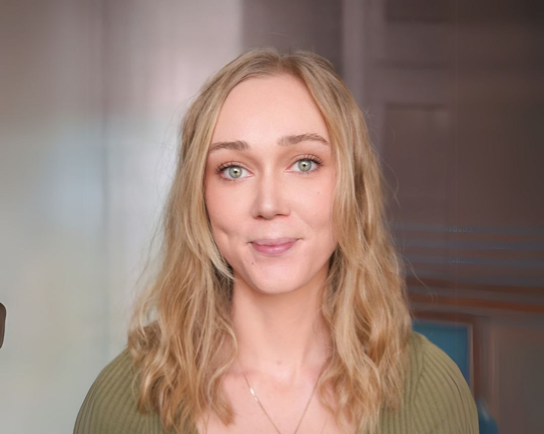Person with long blonde hair wearing a green top