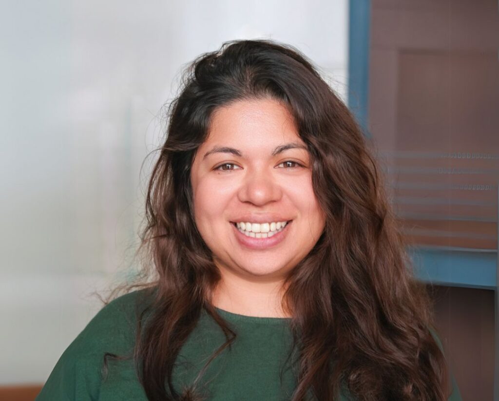 Person with long dark hair, wearing a green top