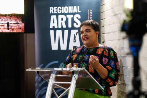woman standing in front of microphone speaking