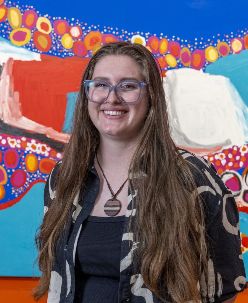 Woman smiling in front of bright painting