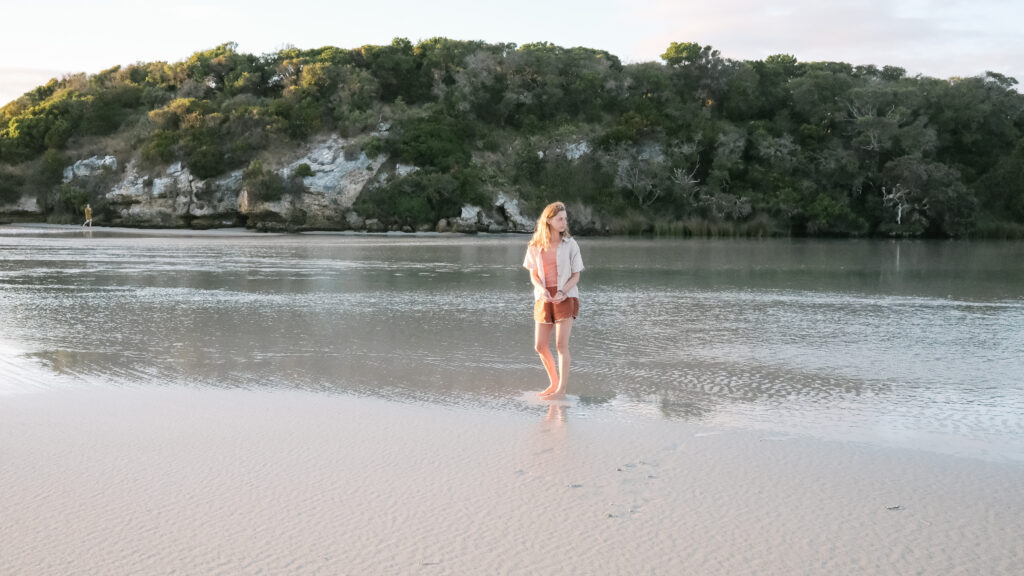 A woman standing in shallow waters.