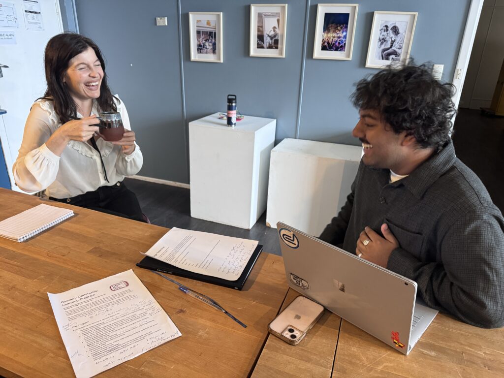 two people sitting at a desk talking