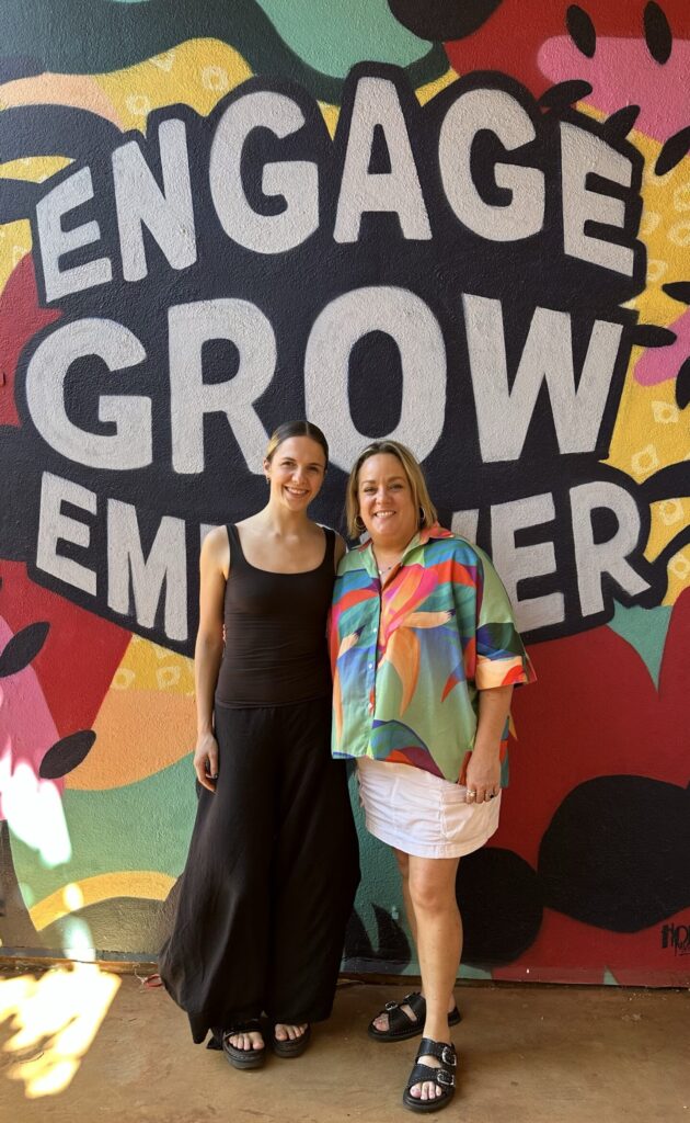 Two women standing in front of a wall that says Engage Grow Empower