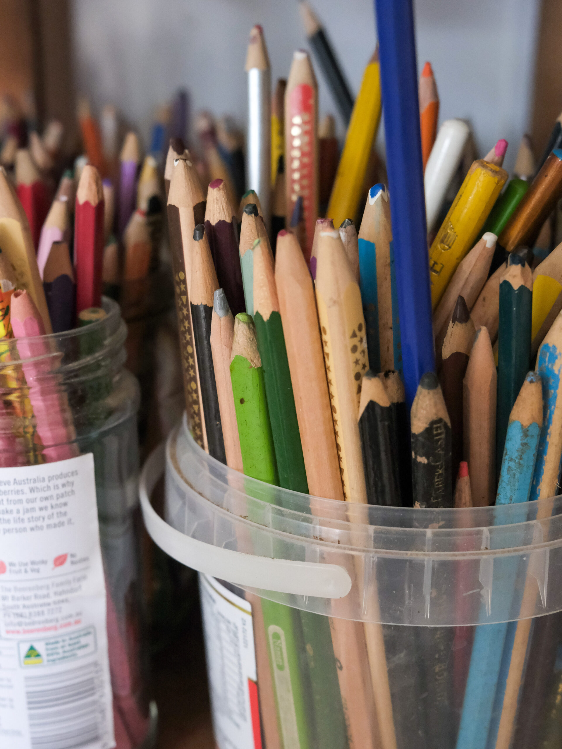A plastic tub of coloured pencils.