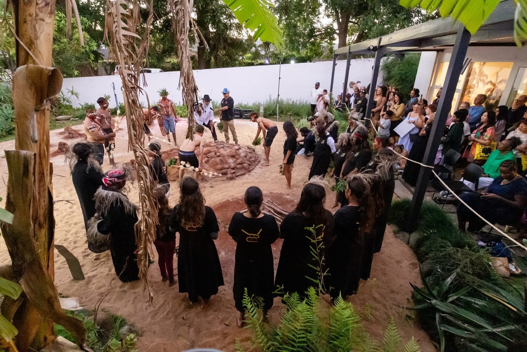 People in a circle viewing an Aboriginal ceremony.
