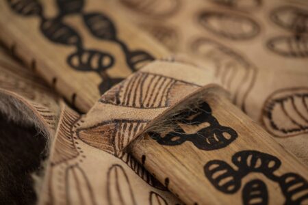 Close up photo of burnt leather and burnt wood artwork.