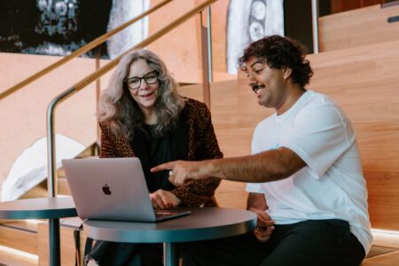 Two people looking at a laptop screen.